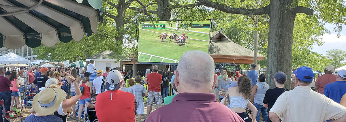 led screen rentals in las vegas displaying horse racing to a crowd of people